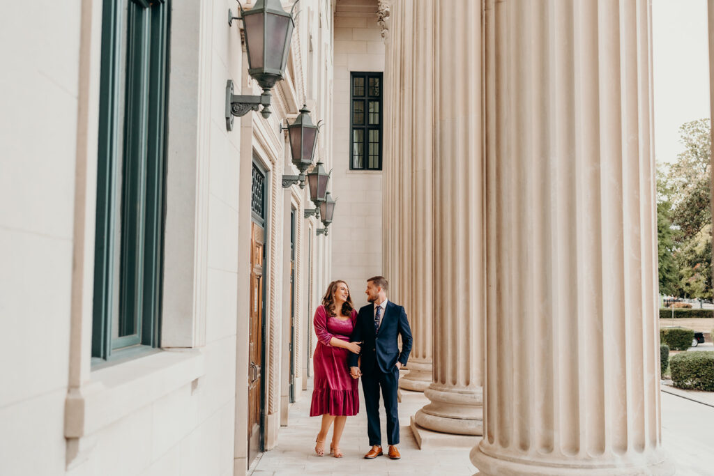 Couple standing in front of the columns at the old courthouse in charlotte