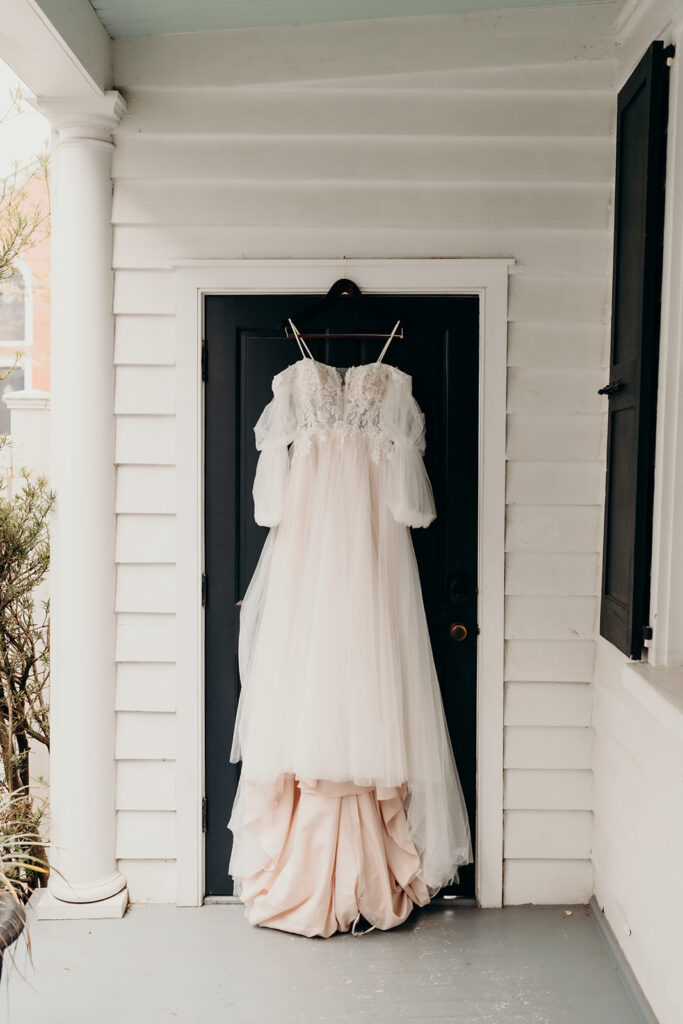 wedding dress hanging in door