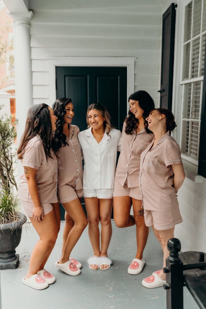 bride laughing with bridesmaids on porch