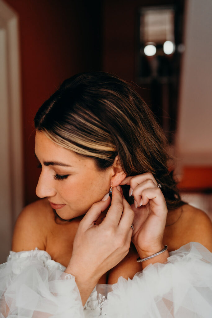 bride putting on her jewelry