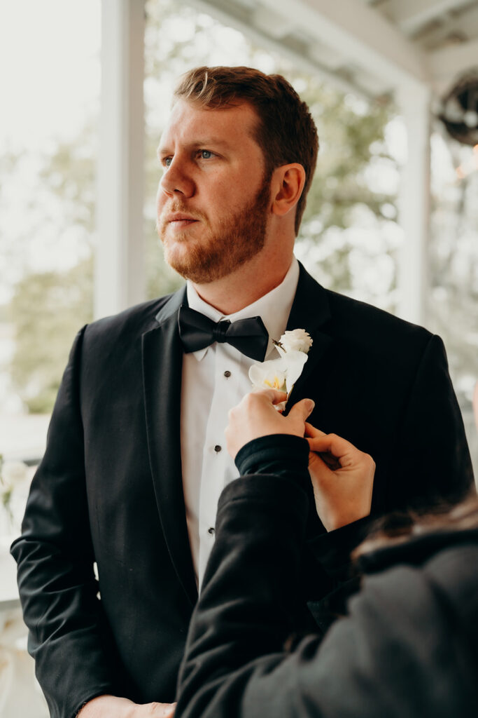 groom putting on boutonniere Creek Club At I'On