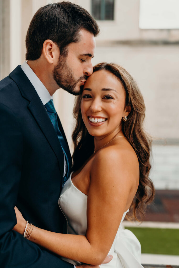 couple in white dress and navy blue suit and tie at classic courthouse building in uptown charlotte