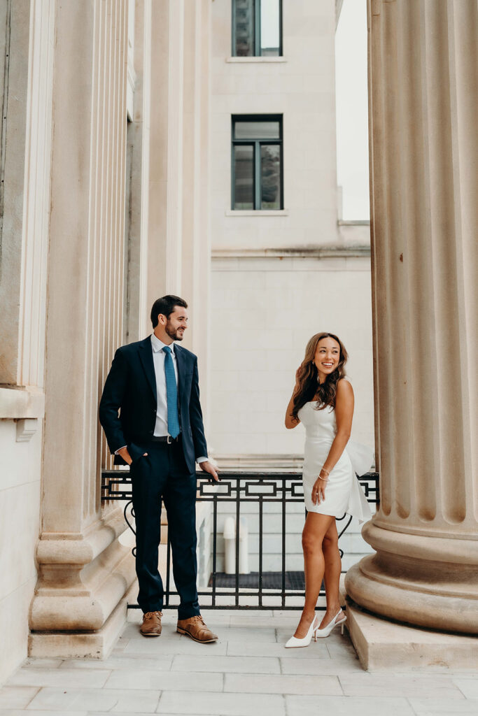 couple in white dress and navy blue suit and tie at classic courthouse building in uptown charlotte