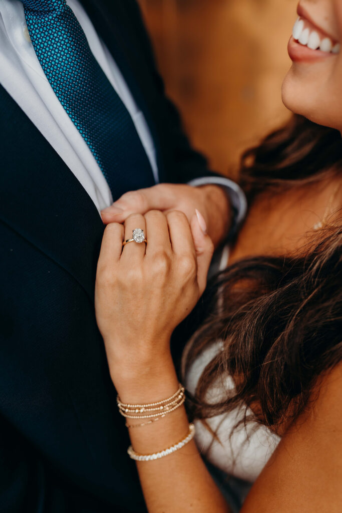 couple in white dress and navy blue suit and tie at classic courthouse building