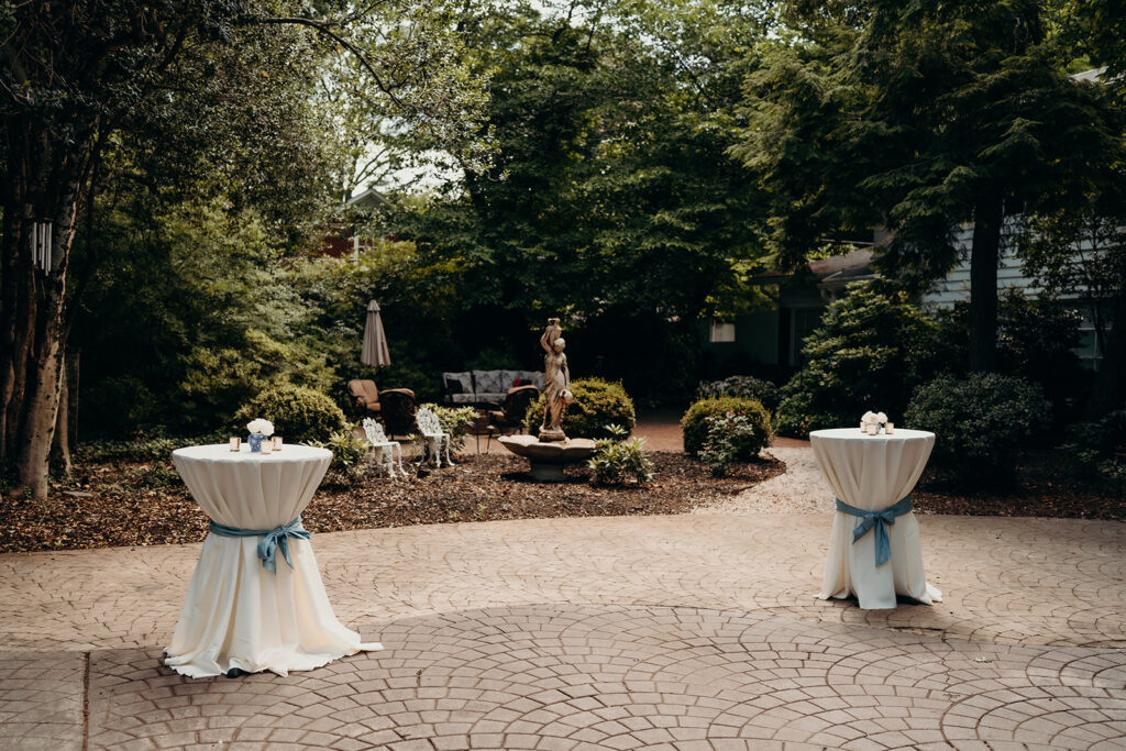 Summer wedding ceremony in secret private courtyard on a sunny day with lush greenery and blue flowers