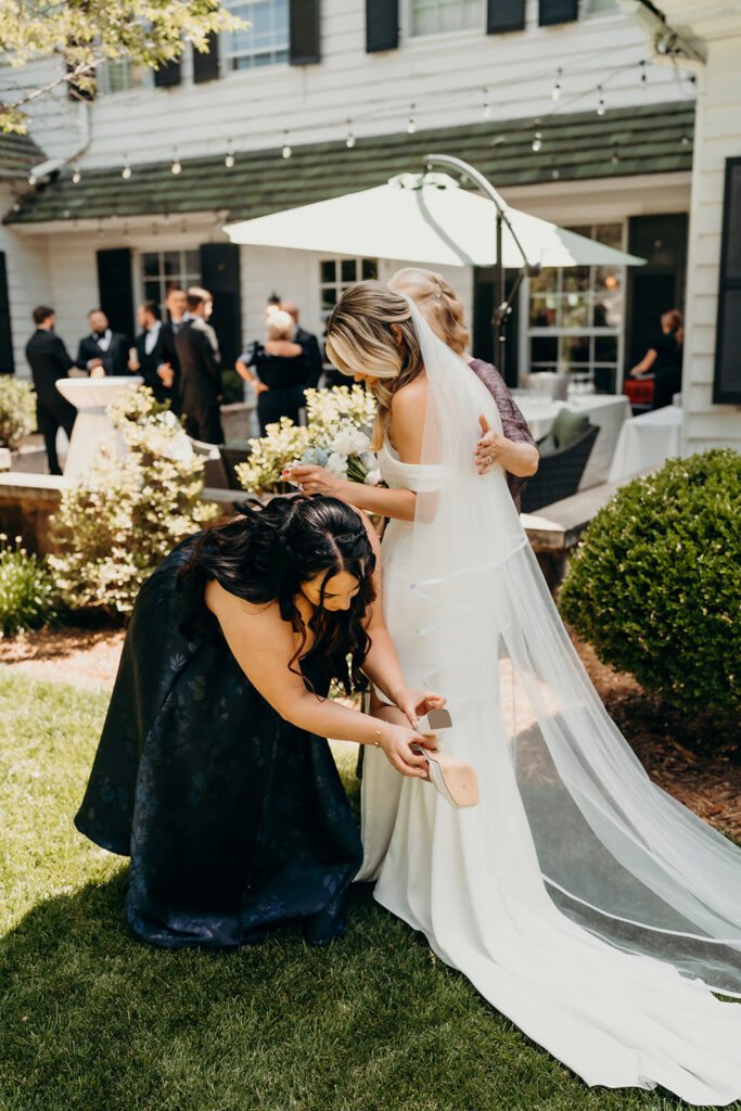 Bridesmaid fixing brides outfit