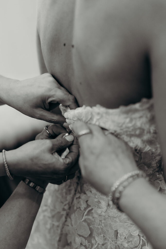 Bride getting ready photos getting into dress and putting on jewelry