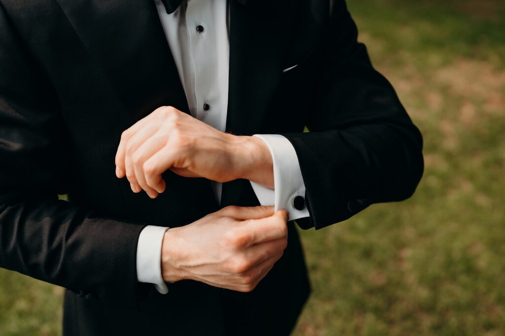 groom getting ready outdoors by the river at magnolia plantation