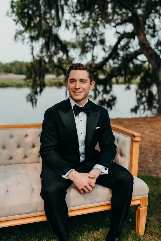 groom getting ready outdoors by the river at magnolia plantation