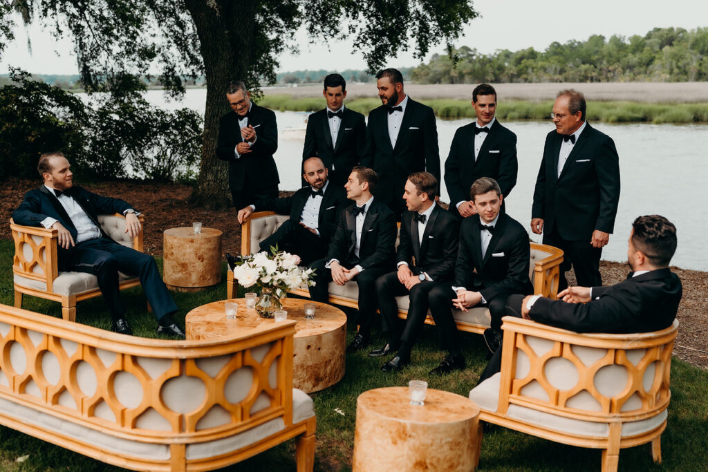 groom getting ready outdoors by the river at magnolia plantation