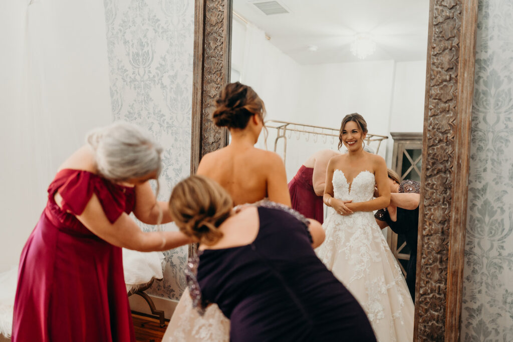 Bride getting ready photos getting into dress and putting on jewelry