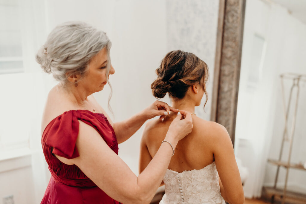 Bride getting ready photos getting into dress and putting on jewelry