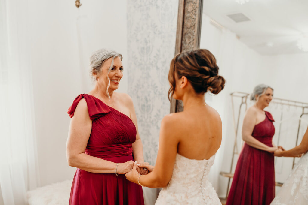 Bride getting ready photos getting into dress and putting on jewelry