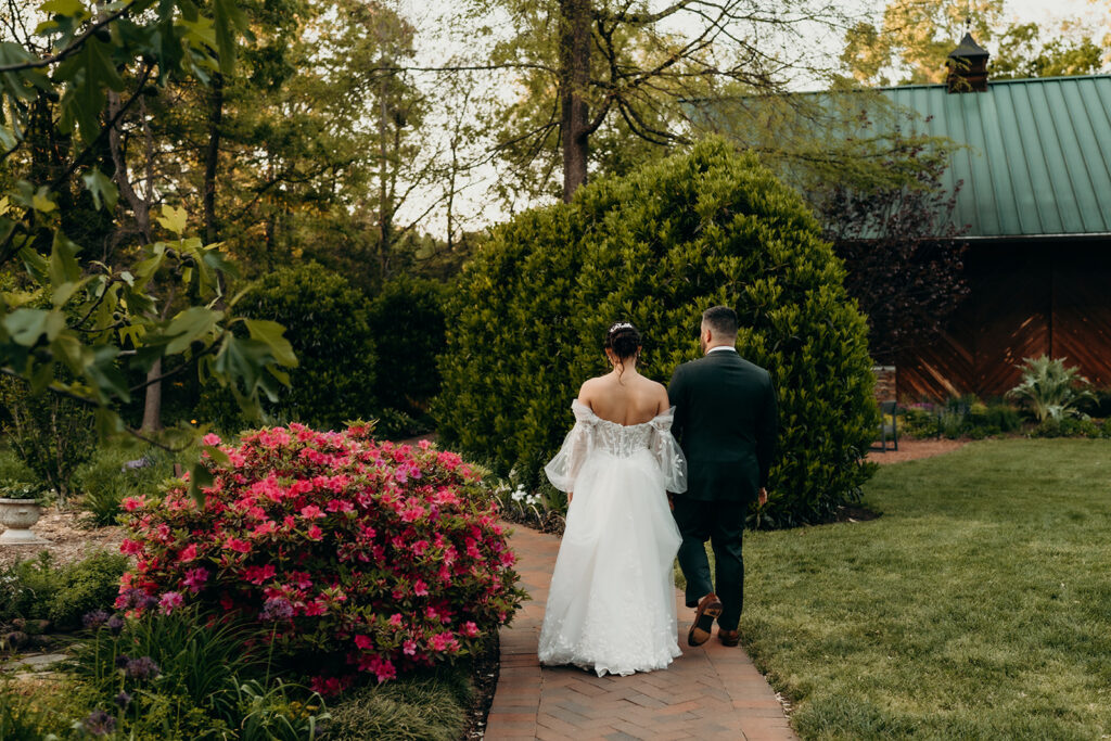 couple walking down path with barn in the background | Barn Wedding Venues in Charlotte