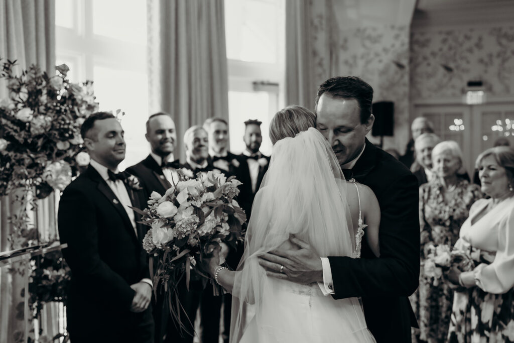 wedding ceremony at a Charlotte Country Club Wedding Venue where dad is giving away the bride and hugging her