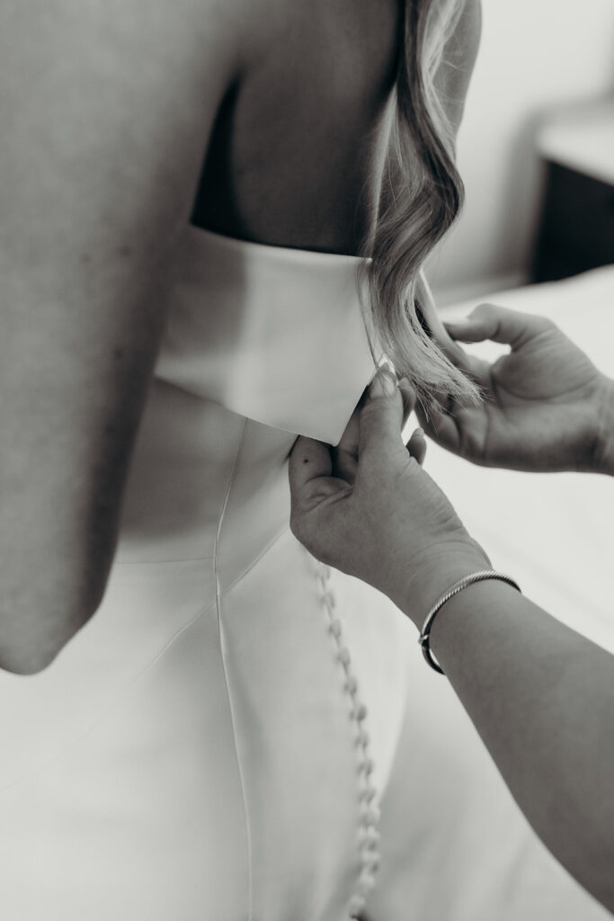 bride getting into dress wedding at the cedar room