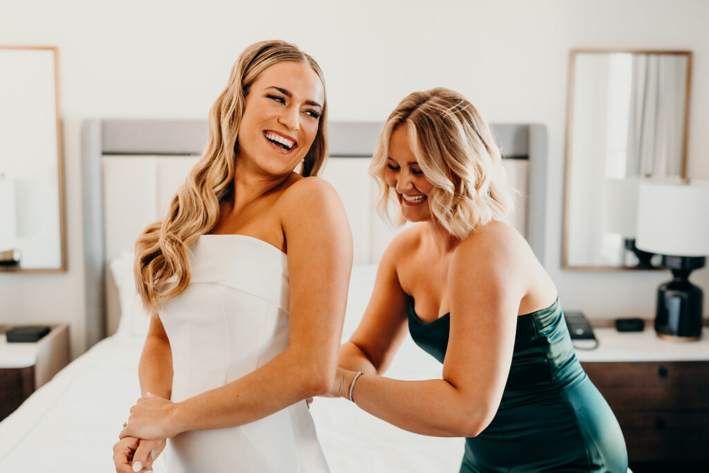 bride getting into dress wedding at the cedar room