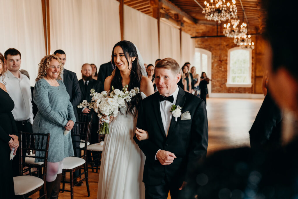 bride and dad walking down aisle during ceremony at melrose knitting mill