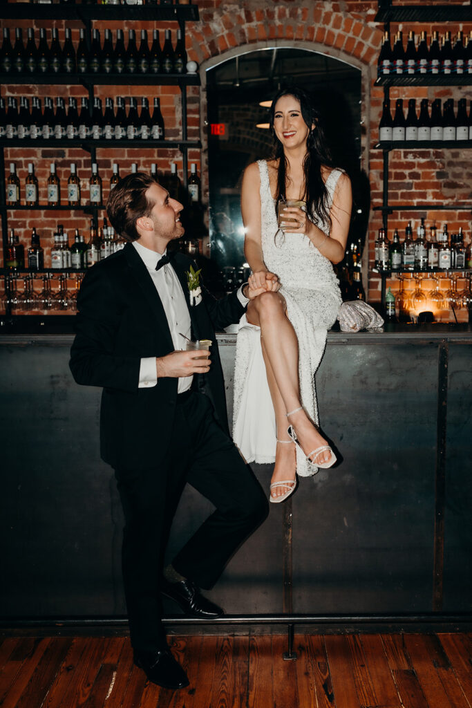 couple taking photos sitting on the bar at Melrose Knitting Mill