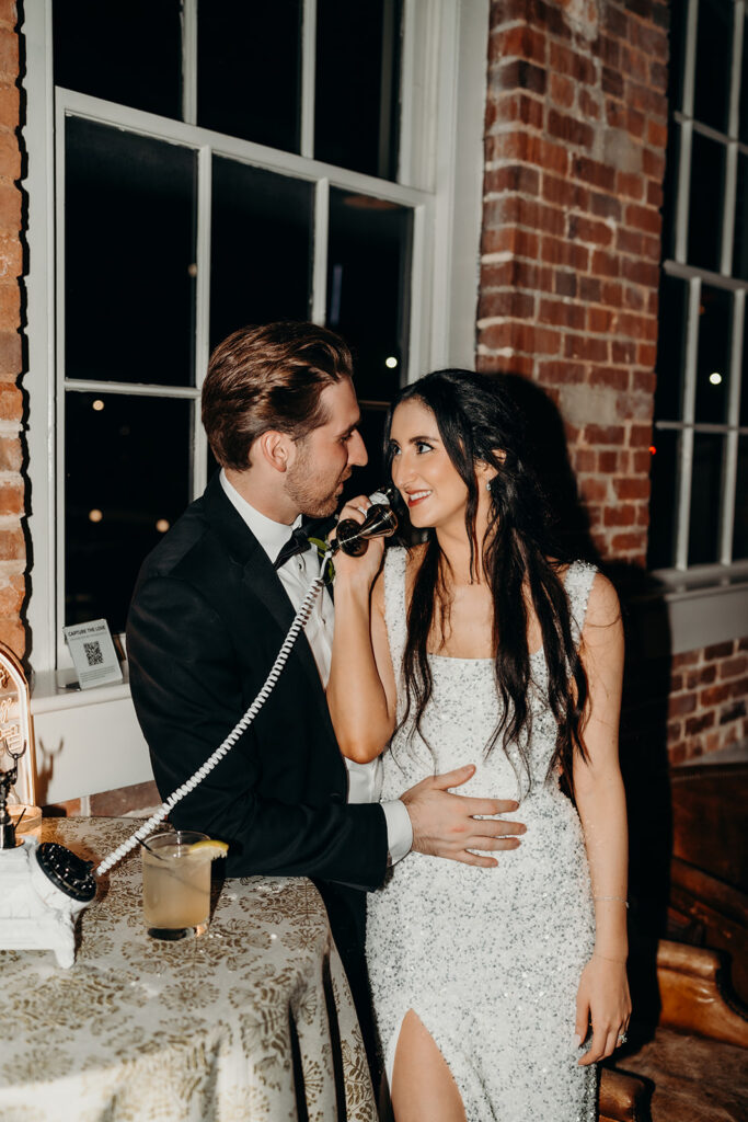 couple leaving voicemail for their guestbook at Melrose Knitting Mill