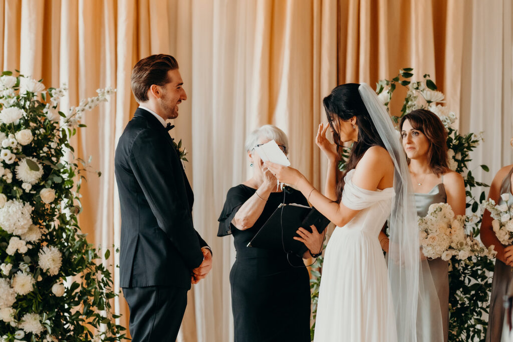 couple reading vows during ceremony at melrose knitting mill