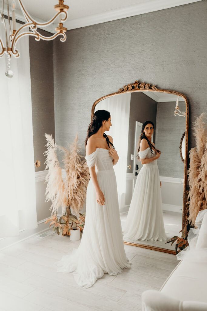 bride looking at herself in mirror while getting ready
