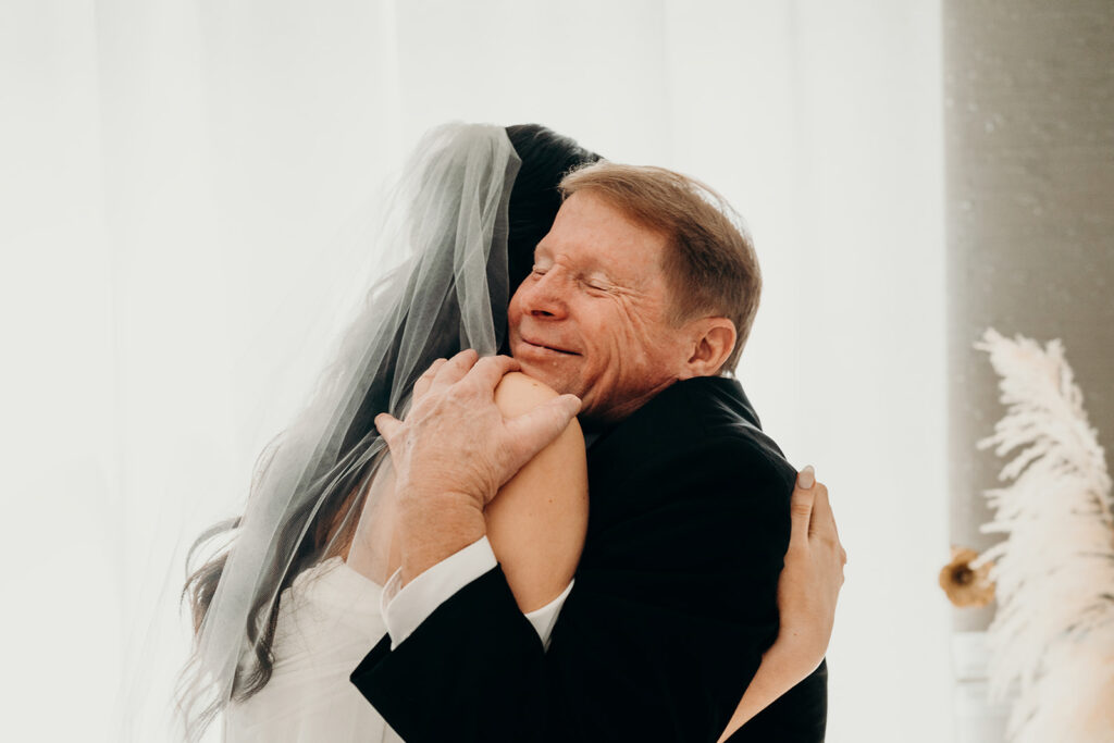 bride and dad hugging during first look