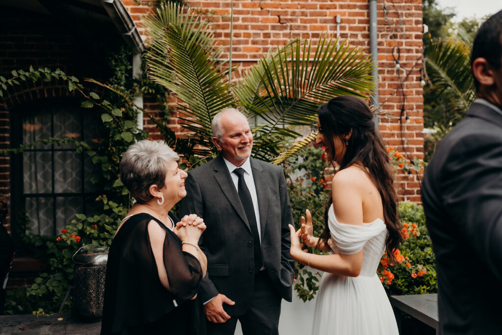 people socializing at couples portraits outside melrose knitting mill during cocktail hour