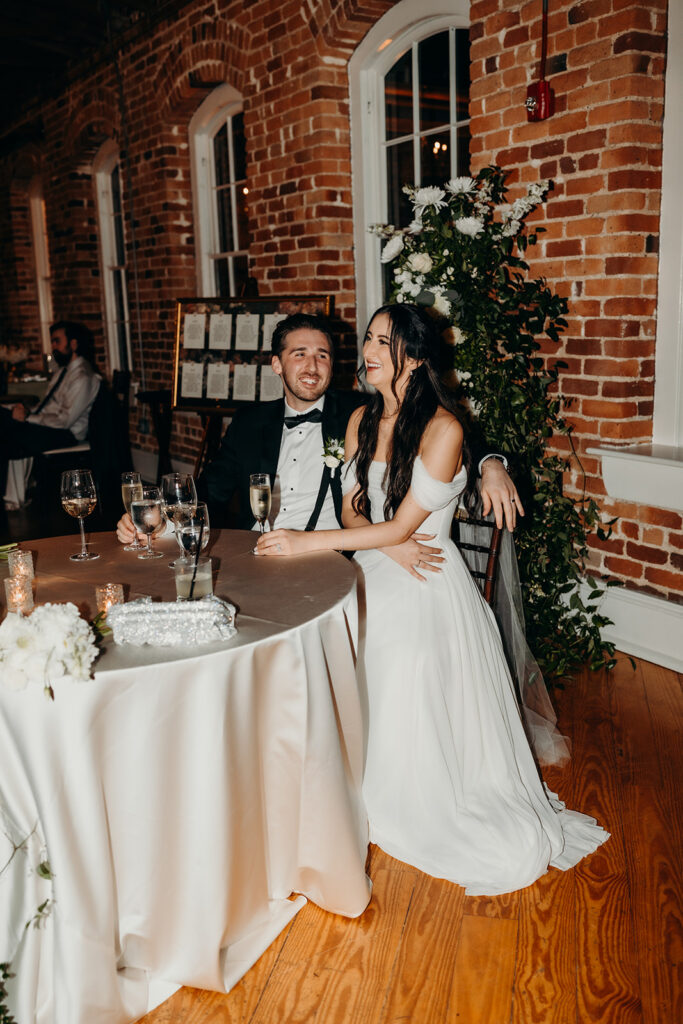 couple reacting with laughter to toasts at Melrose Knitting Mill