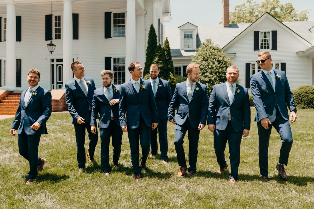groom and groomsmen walking together at rose hill estate