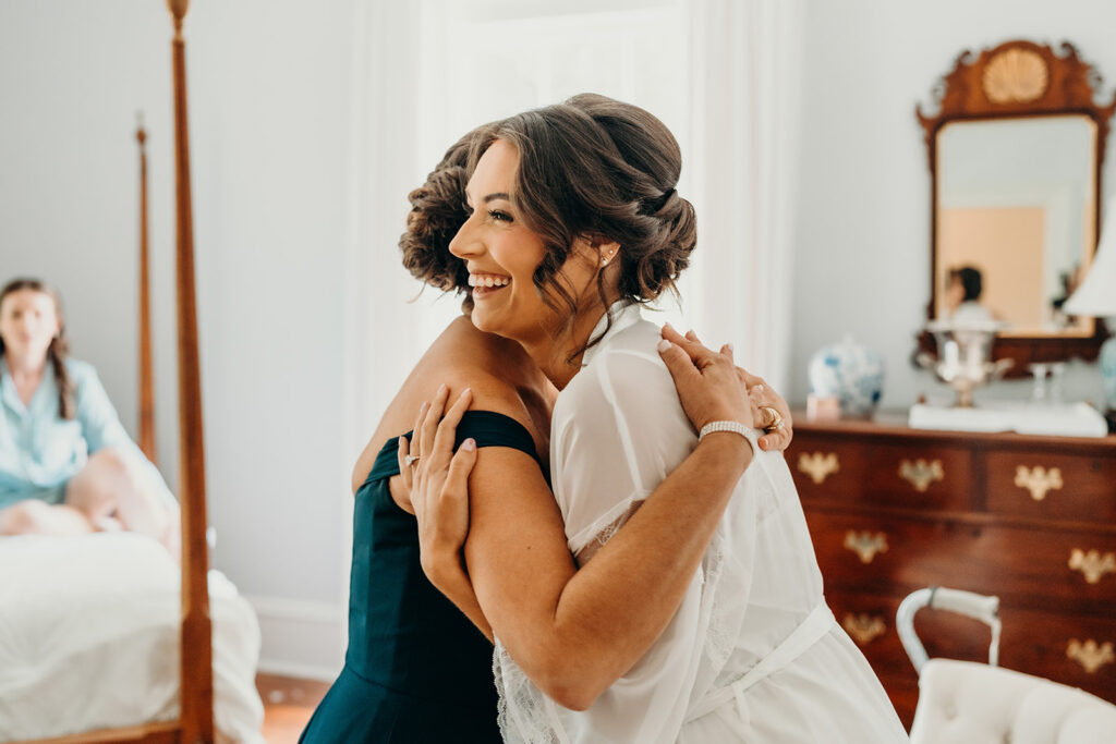 bride hugging mom as she is getting ready at rose hill estate's bridal suite