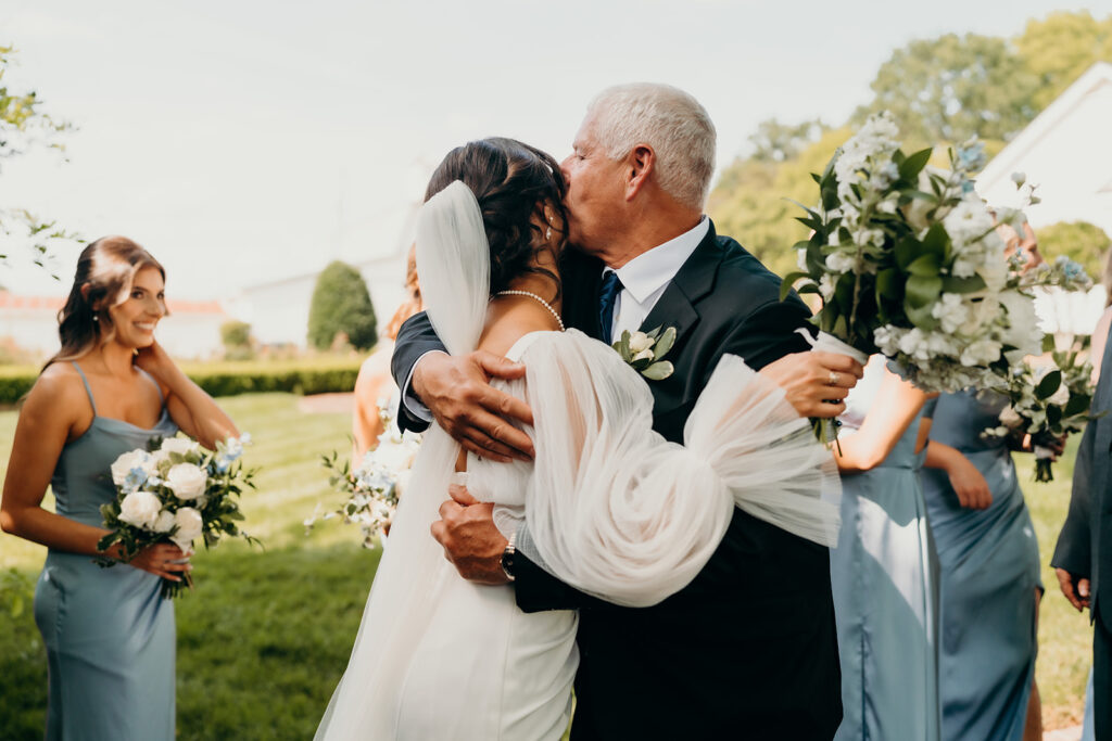 father hugging daughter after ceremony to congratulate her on her marriage