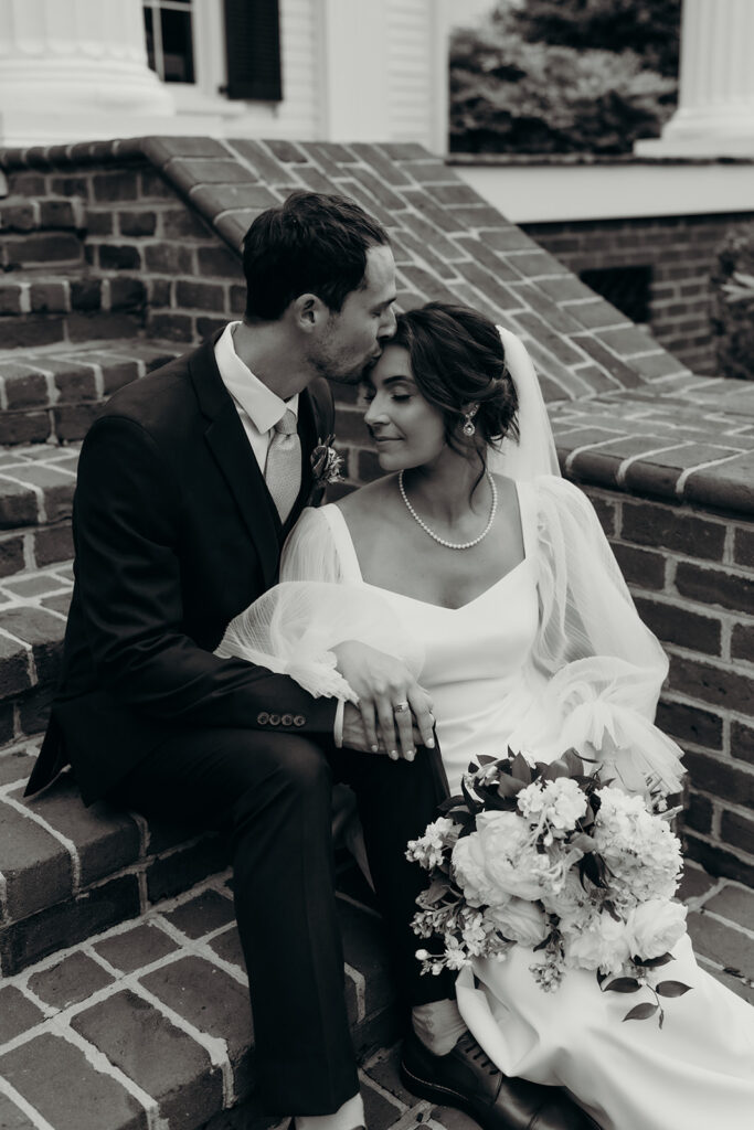 bride and groom sitting on brick steps at their rose hill estate wedding