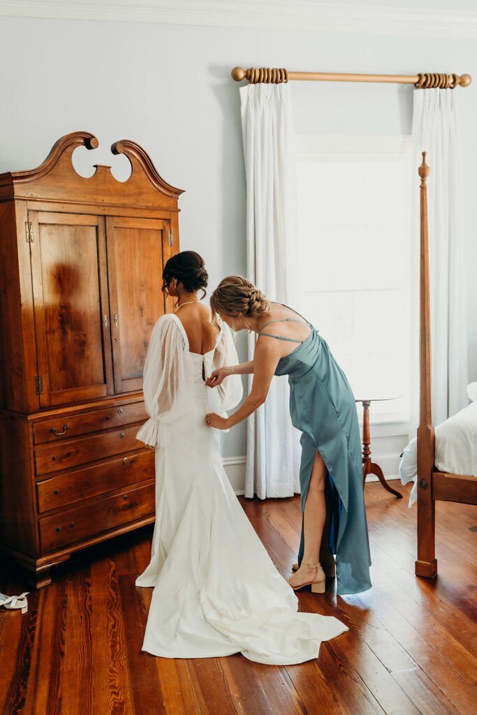 bride getting into her dress at rose hill estate's bridal suite