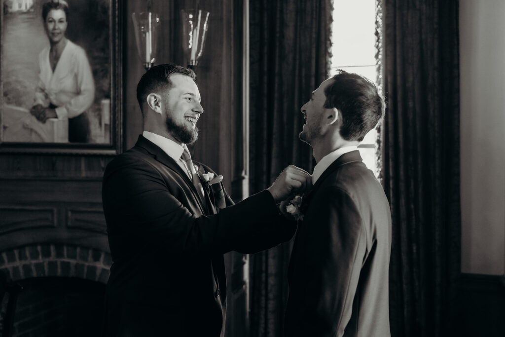 groom getting ready at rose hill estate having boutonnière put on