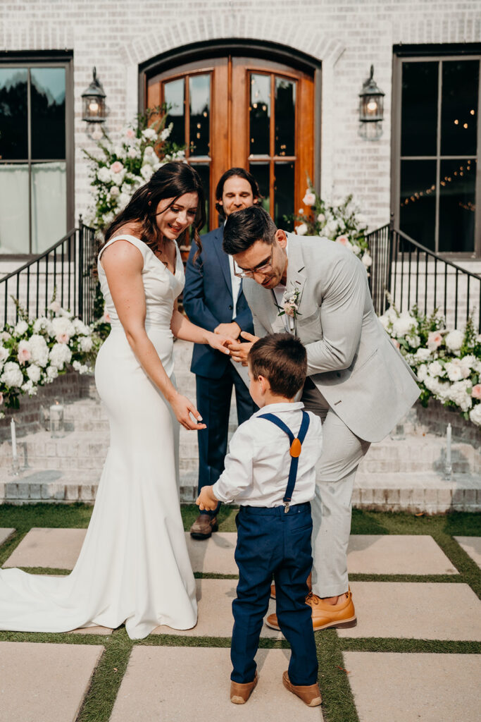 ring bearer handing the couple their rings during the ceremony