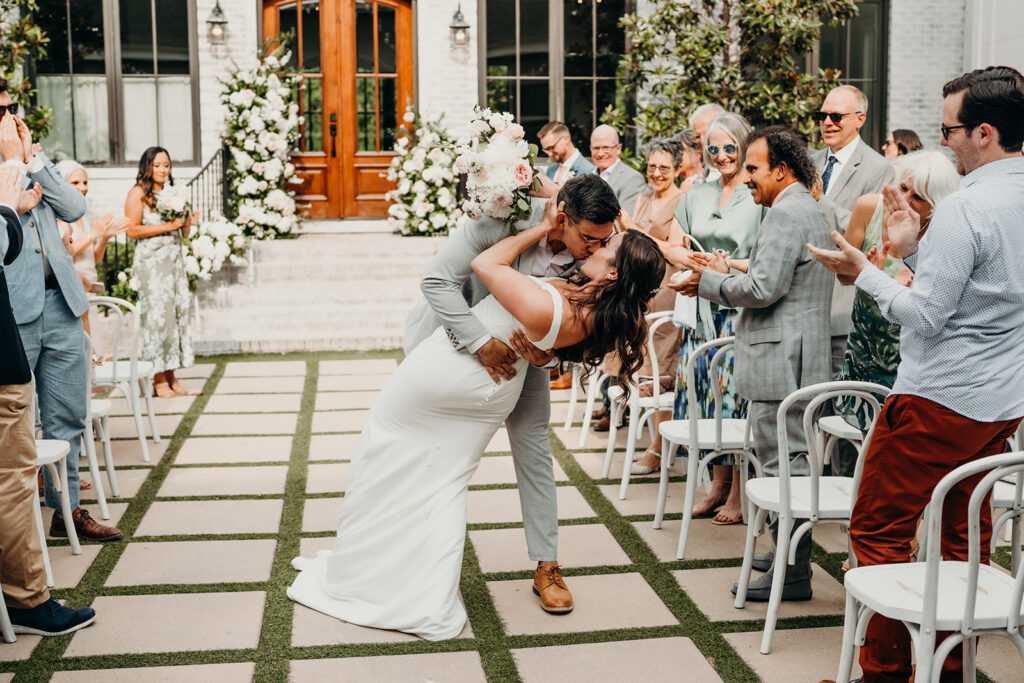 bride and groom kissing as they walk down the aisle after they are husband and wife