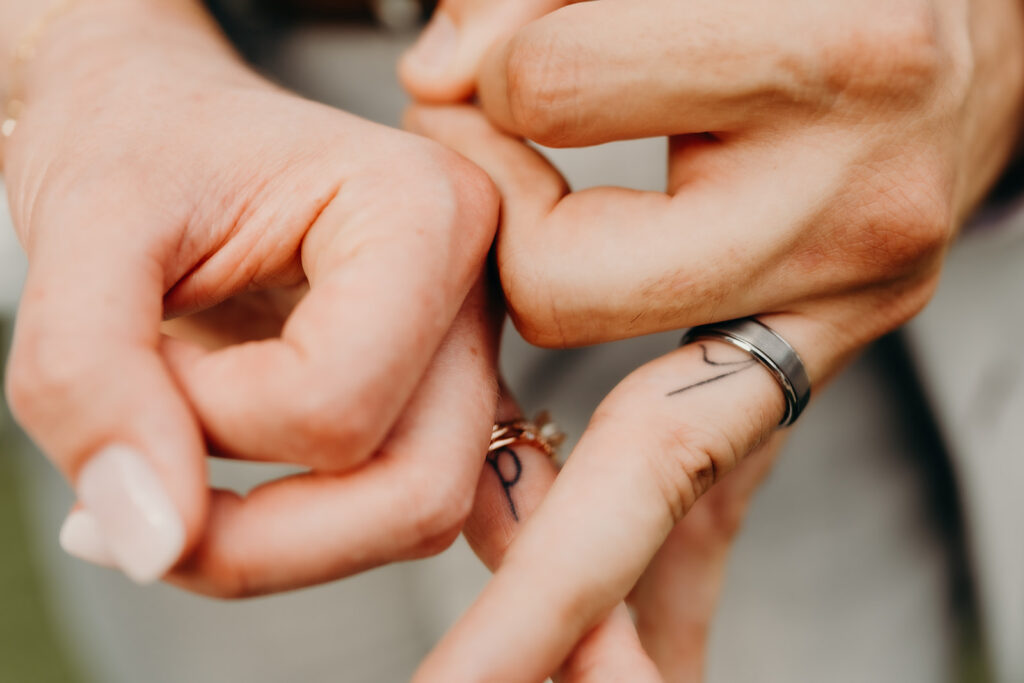 couples matching tattoos on ring finger with initials