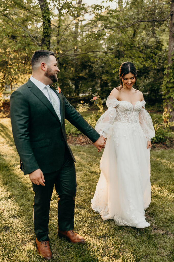 couple walking in front of the woods at golden hour