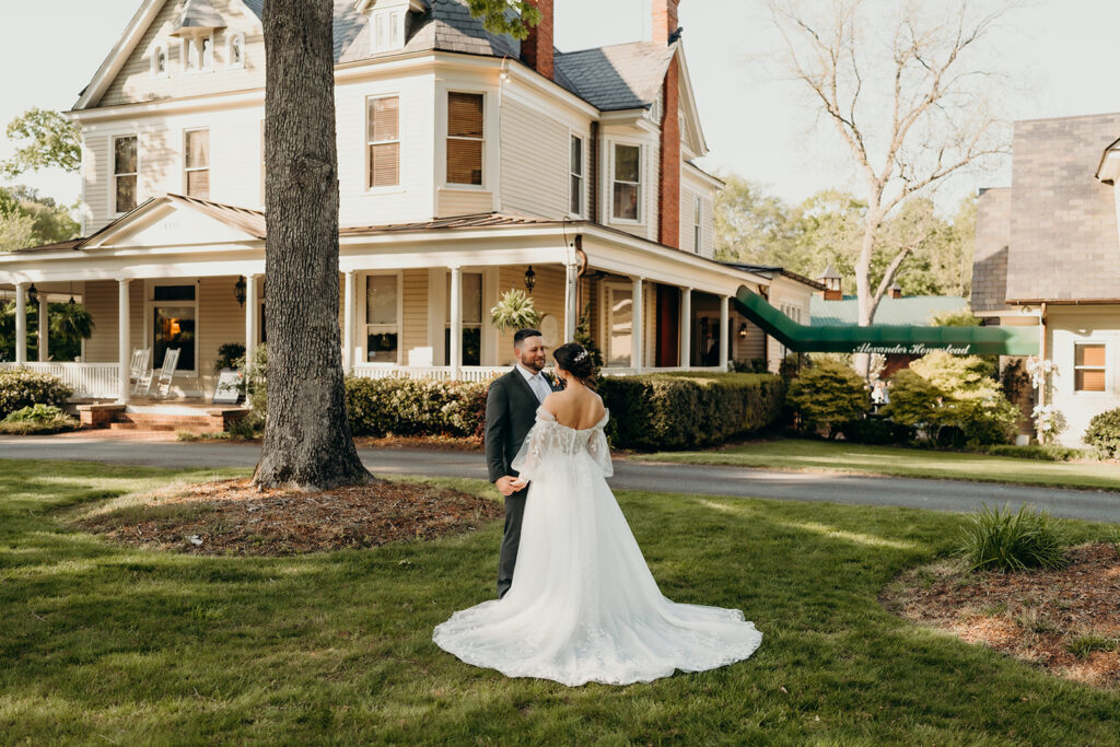 couple's portraits in the front lawn holding each other with the estate in the background