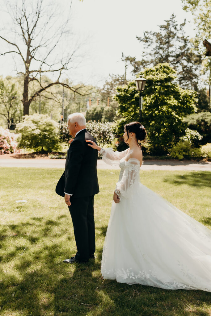 bride and dad doing a first look in the front lawn