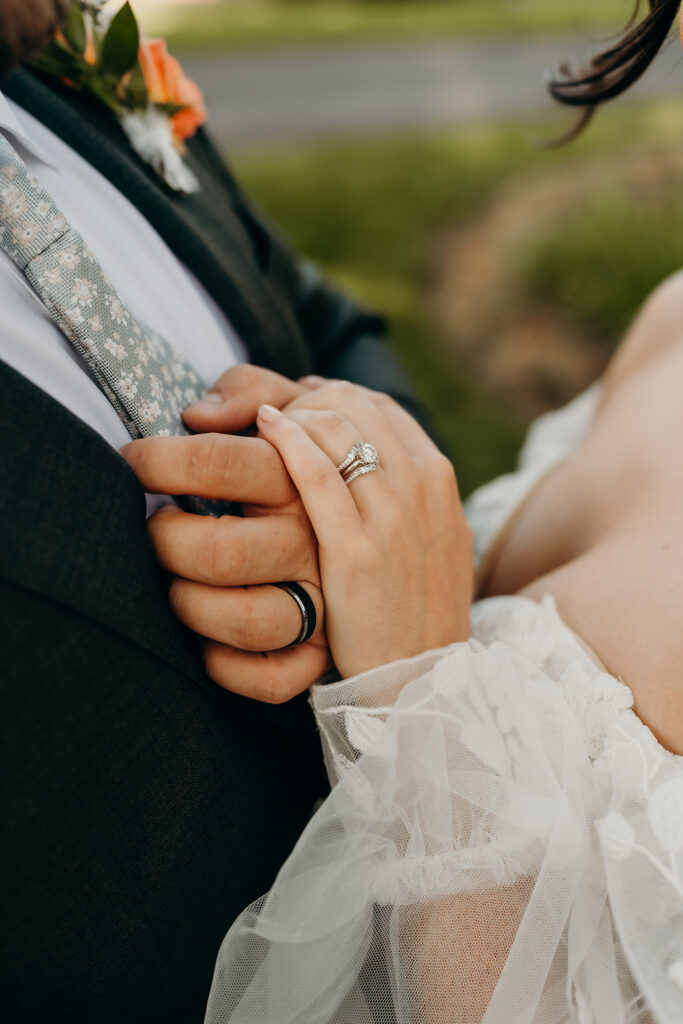 couple's portraits in the front lawn holding hands showing off wedding rings