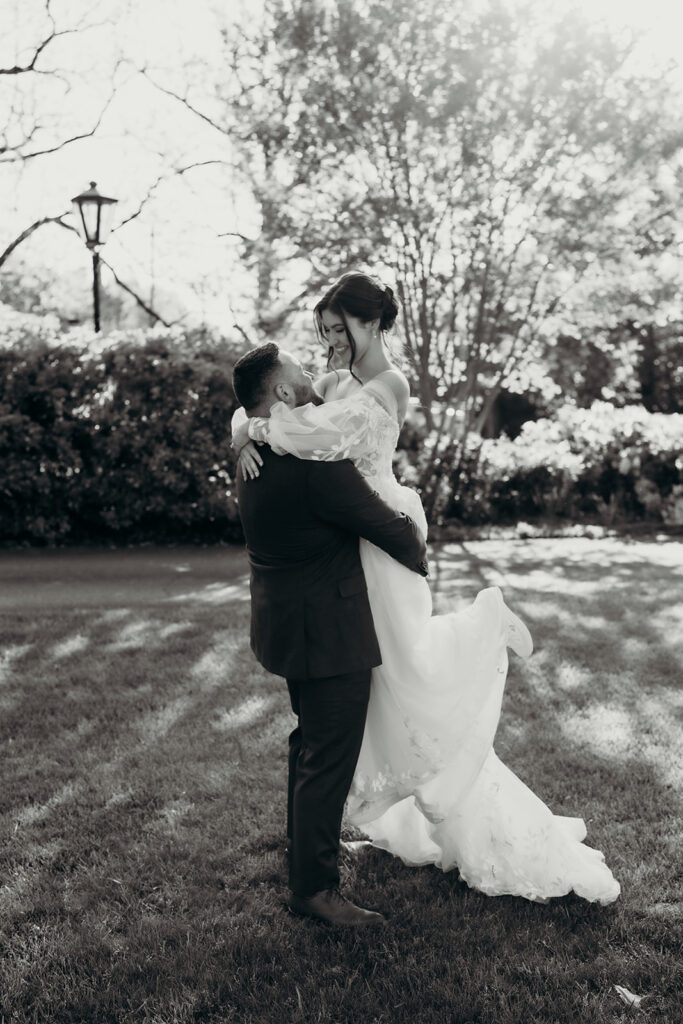 couple's portraits in the front lawn groom picking up the bride