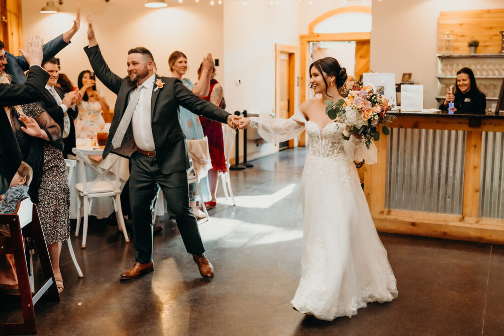 couple entering reception in the barn
