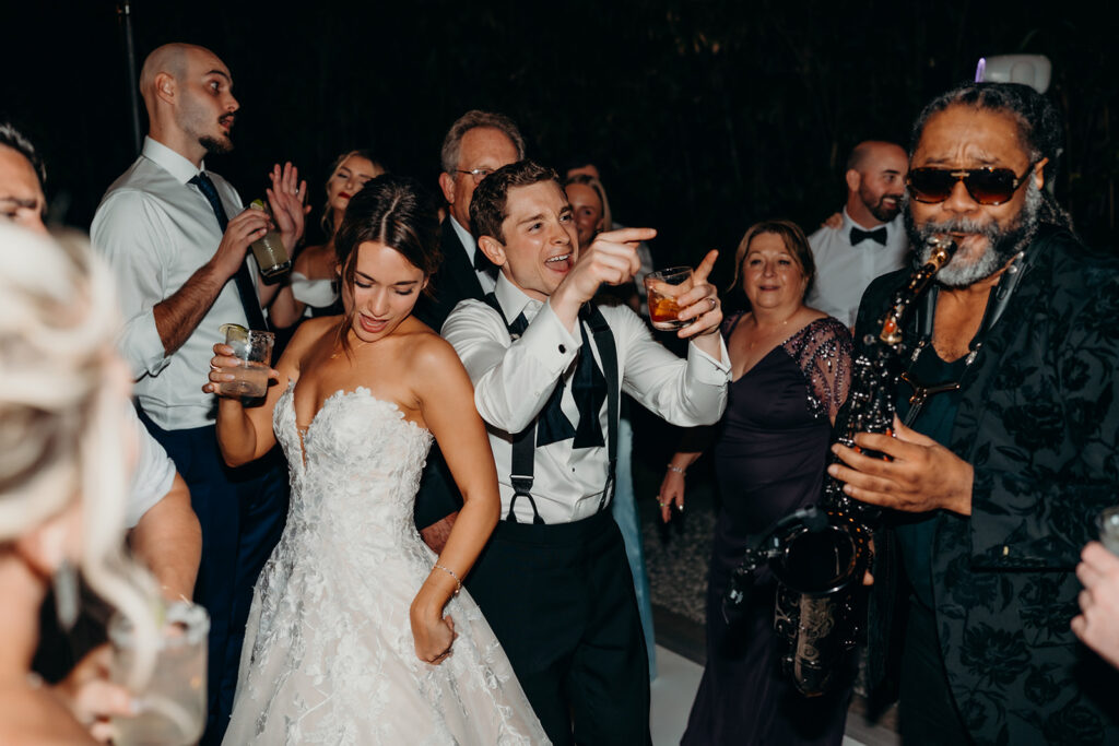 Couple dancing with live sax player at reception