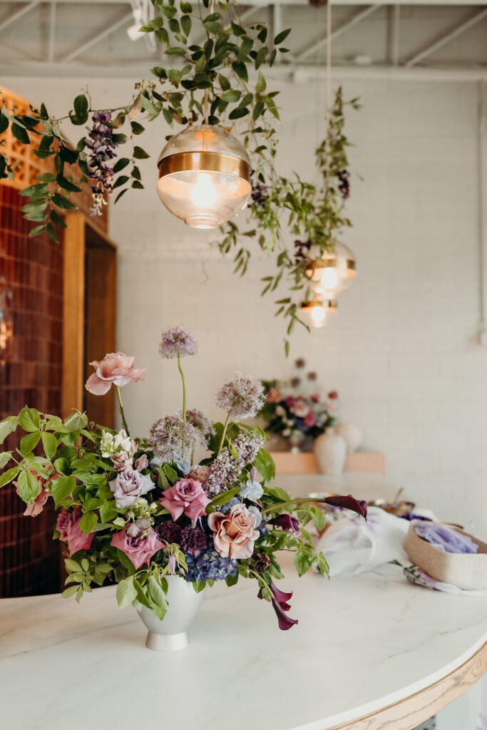 Wedding decor set up on bar with florals and hanging lights