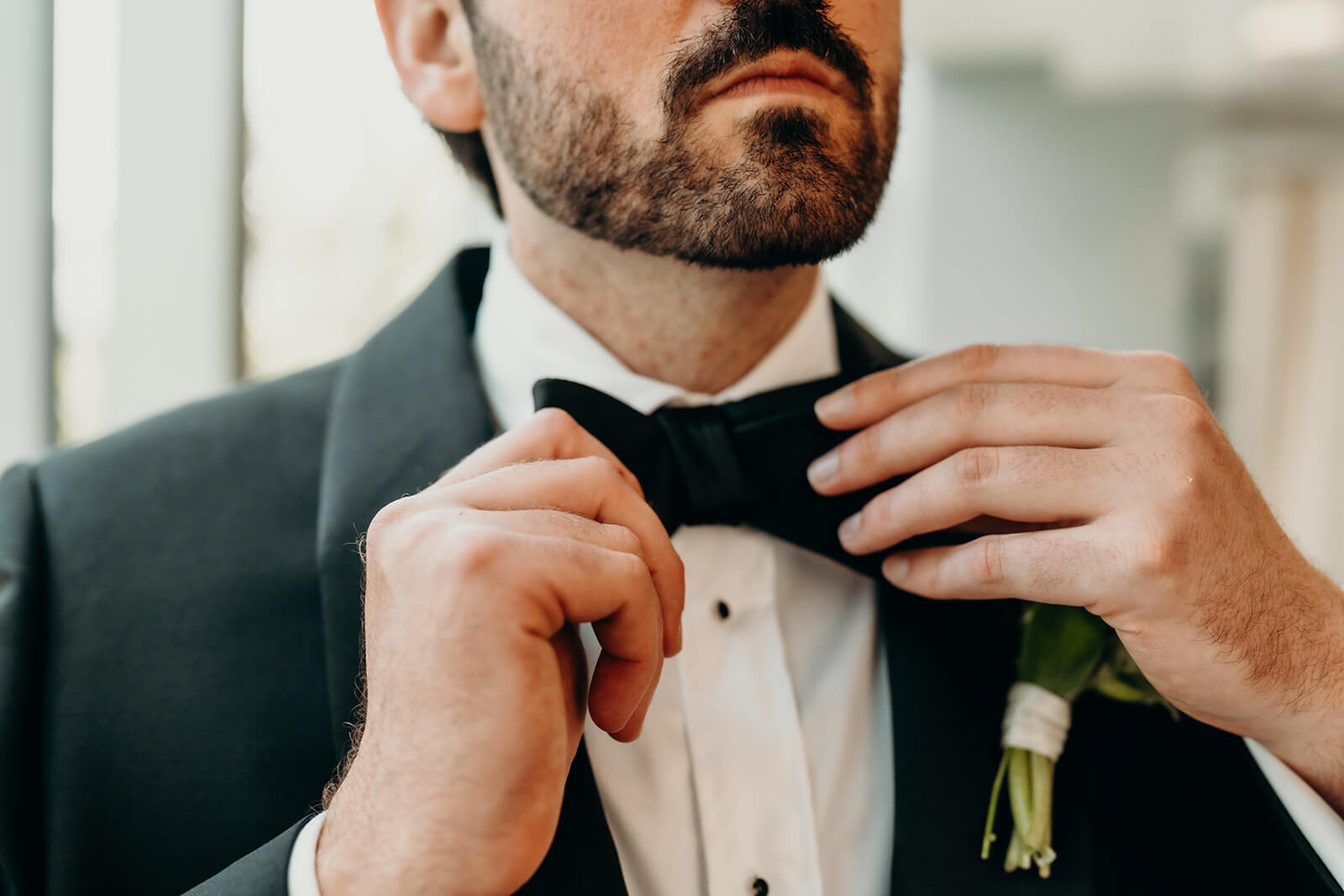 Groom tying bowtie