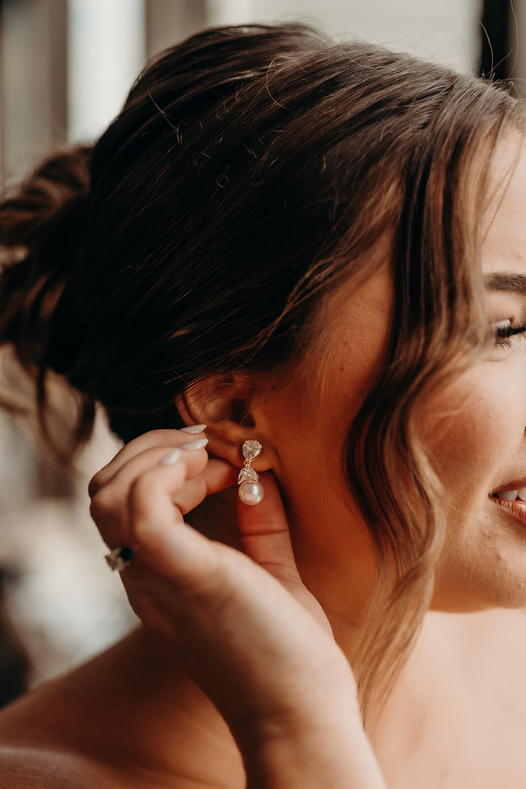 bride putting on jewelry
