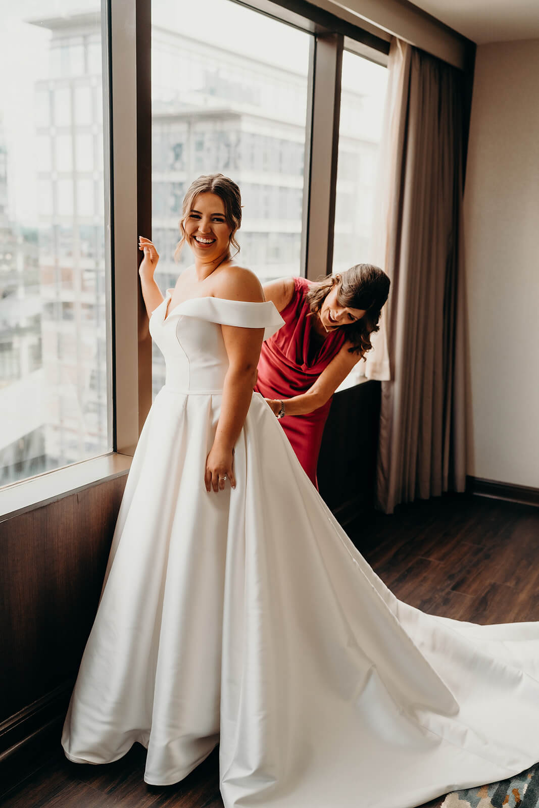 bride's mom helping her get dressed