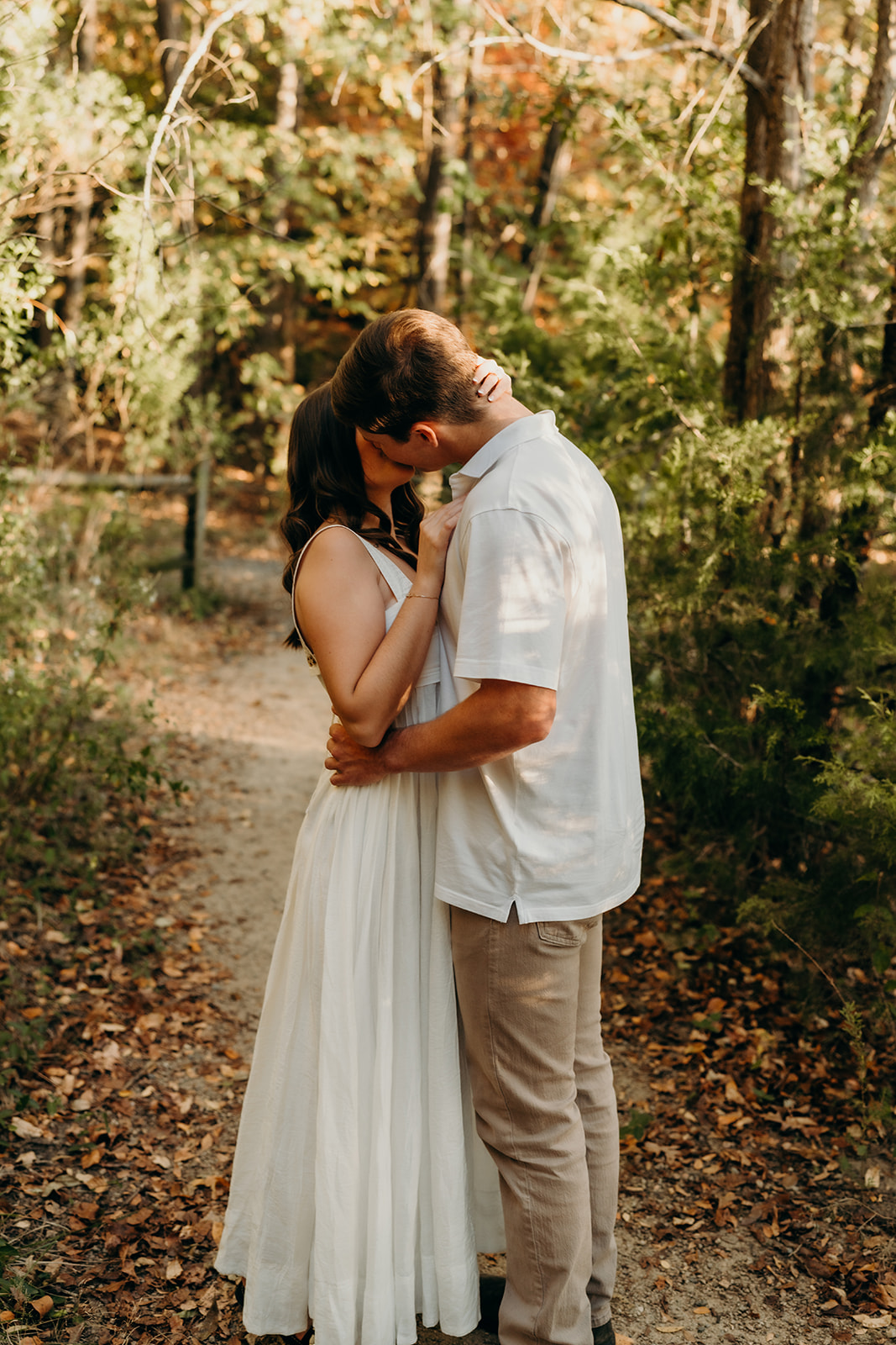 couple kissing on path in the woods